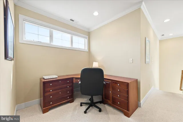 a view of a workspace with furniture and a window