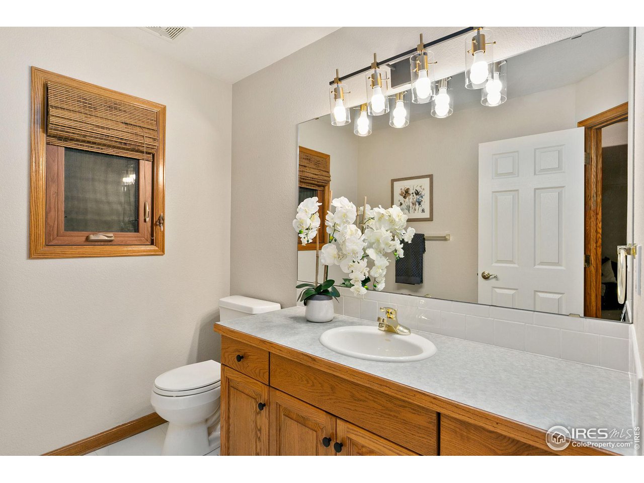32593 Stagecoach Road Windsor, CO 80550 - Photo 15 of 28 a bathroom with a sink a mirror and a toilet