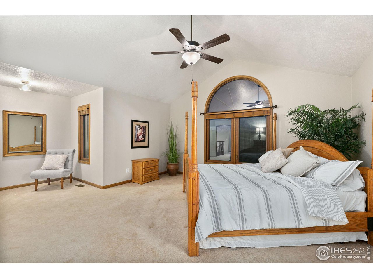 32593 Stagecoach Road Windsor, CO 80550 - Photo 20 of 28 a bedroom with a large bed and a chandelier
