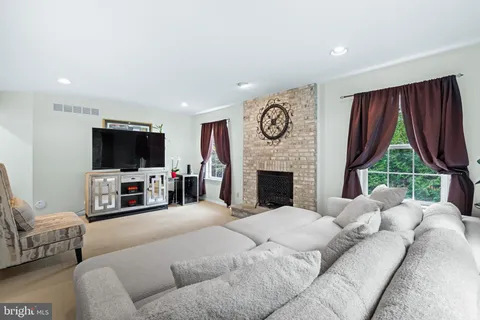 a living room with furniture a large window and a flat screen tv