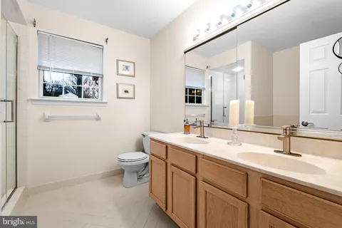 a bathroom with a toilet a sink a mirror and vanity