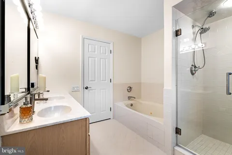 a bathroom with a granite countertop sink a mirror and a bathtub
