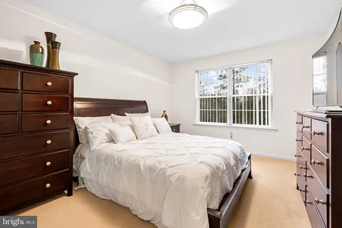 a bedroom with a bed a window and mirror