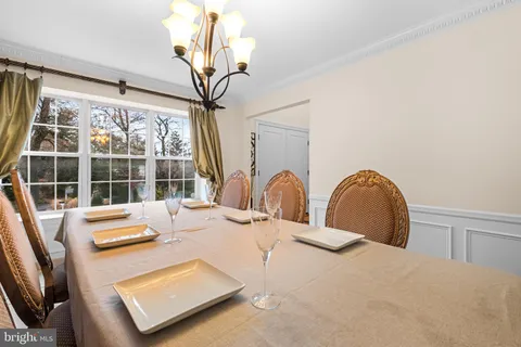 a dining room with wooden floor and a large window