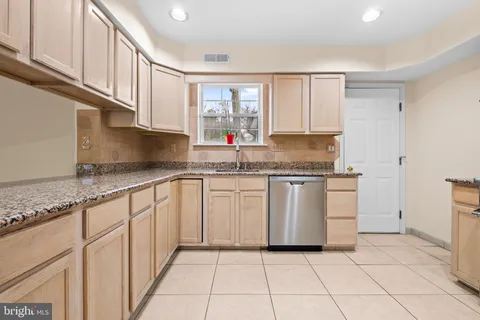 a kitchen with granite countertop white cabinets and white appliances