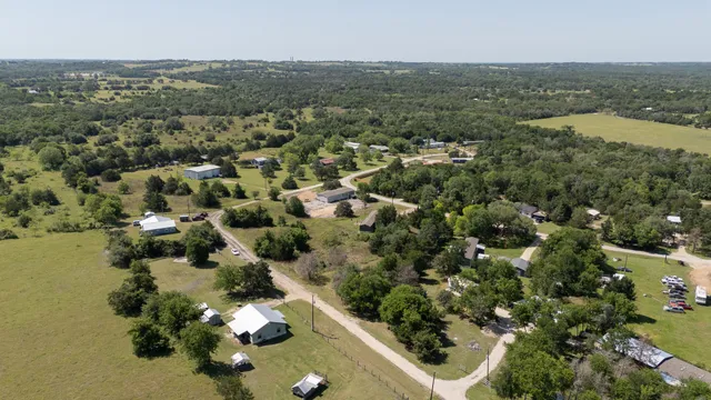 an aerial view of residential house with outdoor space and trees