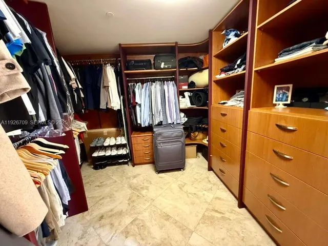 a view of walk in closet with clothes and shoes