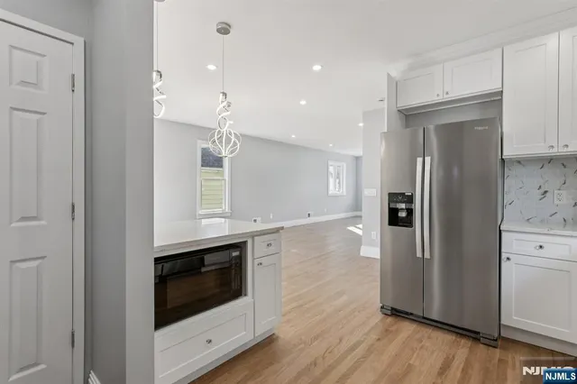 a kitchen with stainless steel appliances granite countertop a refrigerator and a stove top oven