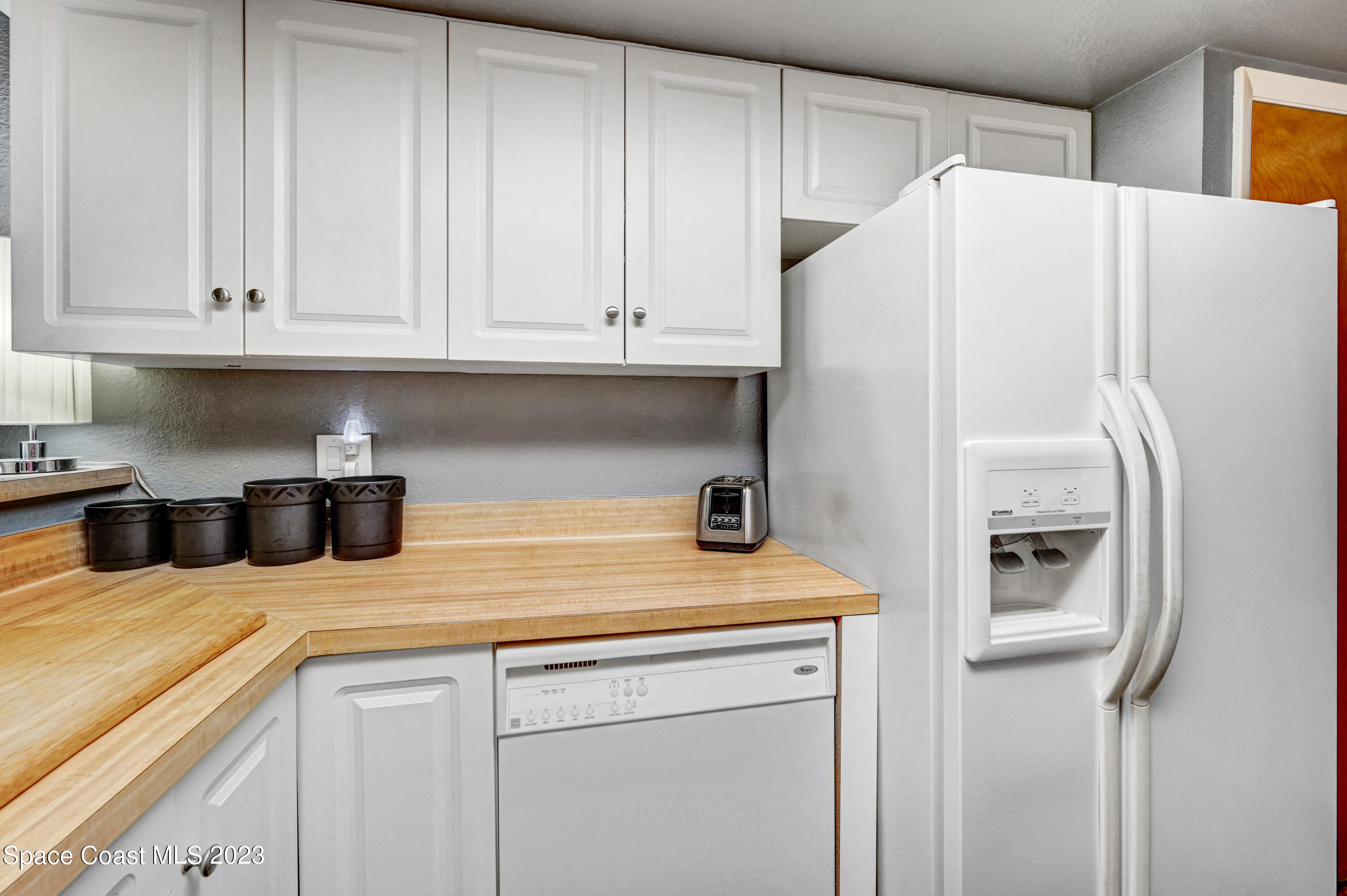 229 Augusta Way Melbourne, FL 32940 - Photo 14 of 39 a kitchen with stainless steel appliances white cabinets and a refrigerator