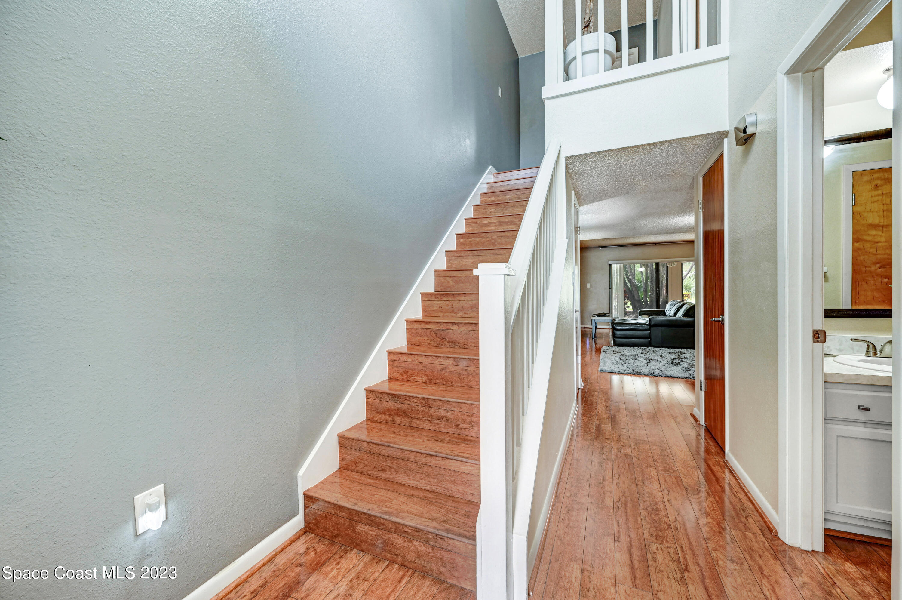 229 Augusta Way Melbourne, FL 32940 - Photo 16 of 39 a view of a hallway with wooden floor and staircase