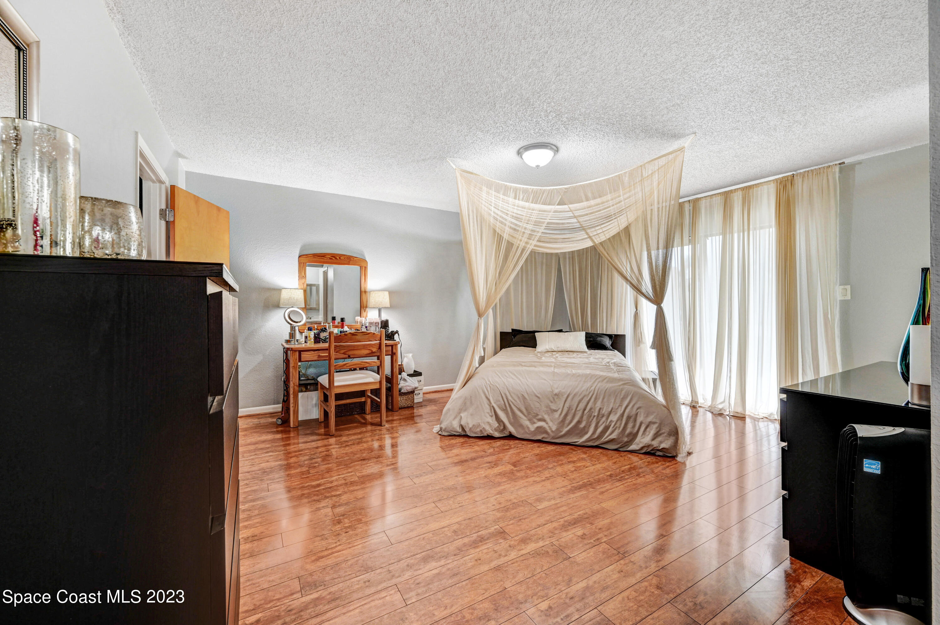 229 Augusta Way Melbourne, FL 32940 - Photo 17 of 39 a spacious bedroom with a bed and a chandelier