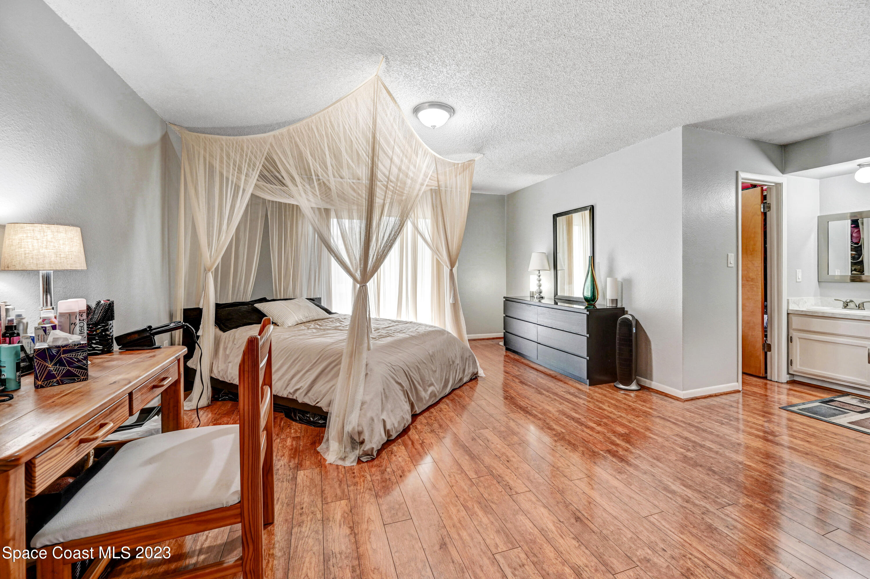 229 Augusta Way Melbourne, FL 32940 - Photo 18 of 39 a spacious bedroom with a bed and wooden floor
