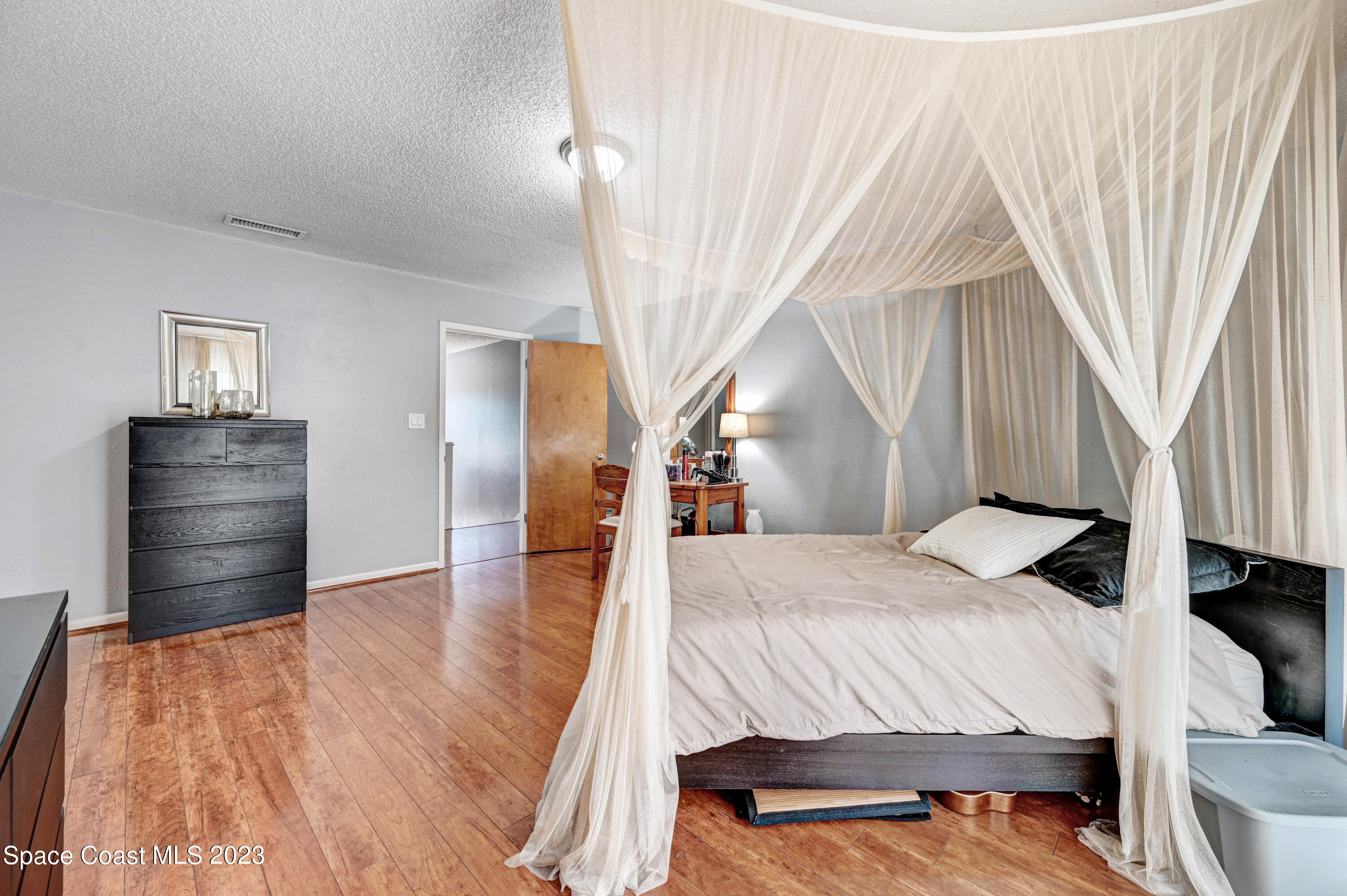 229 Augusta Way Melbourne, FL 32940 - Photo 19 of 39 a bedroom with a bed and a dresser