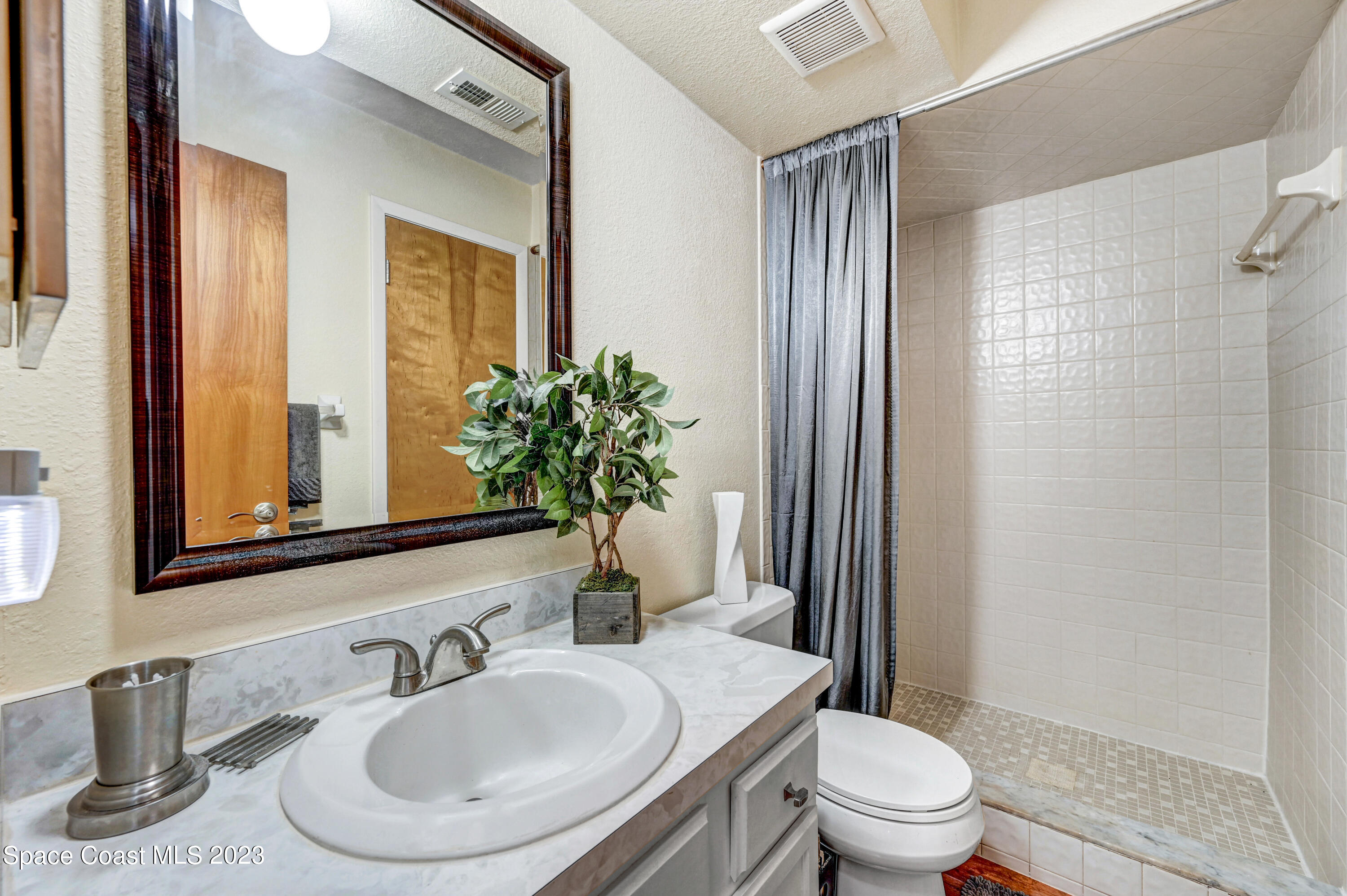 229 Augusta Way Melbourne, FL 32940 - Photo 35 of 39 a bathroom with a sink a toilet a mirror and shower