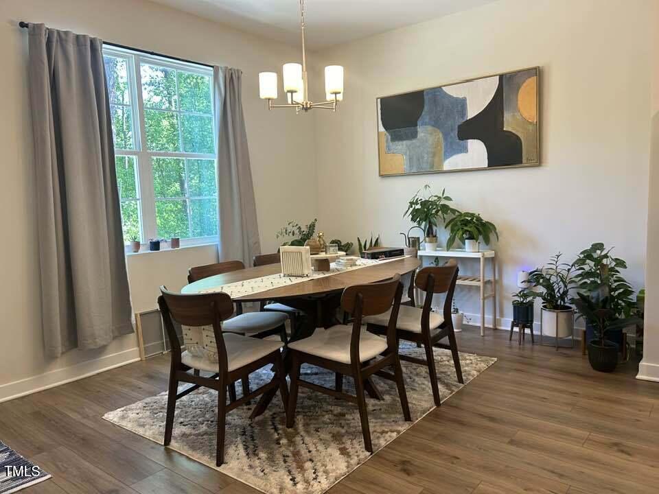 816 Laurel Gate Drive Wake Forest, NC 27587 - Photo 3 of 20 a dining room with furniture potted plants and wooden floor