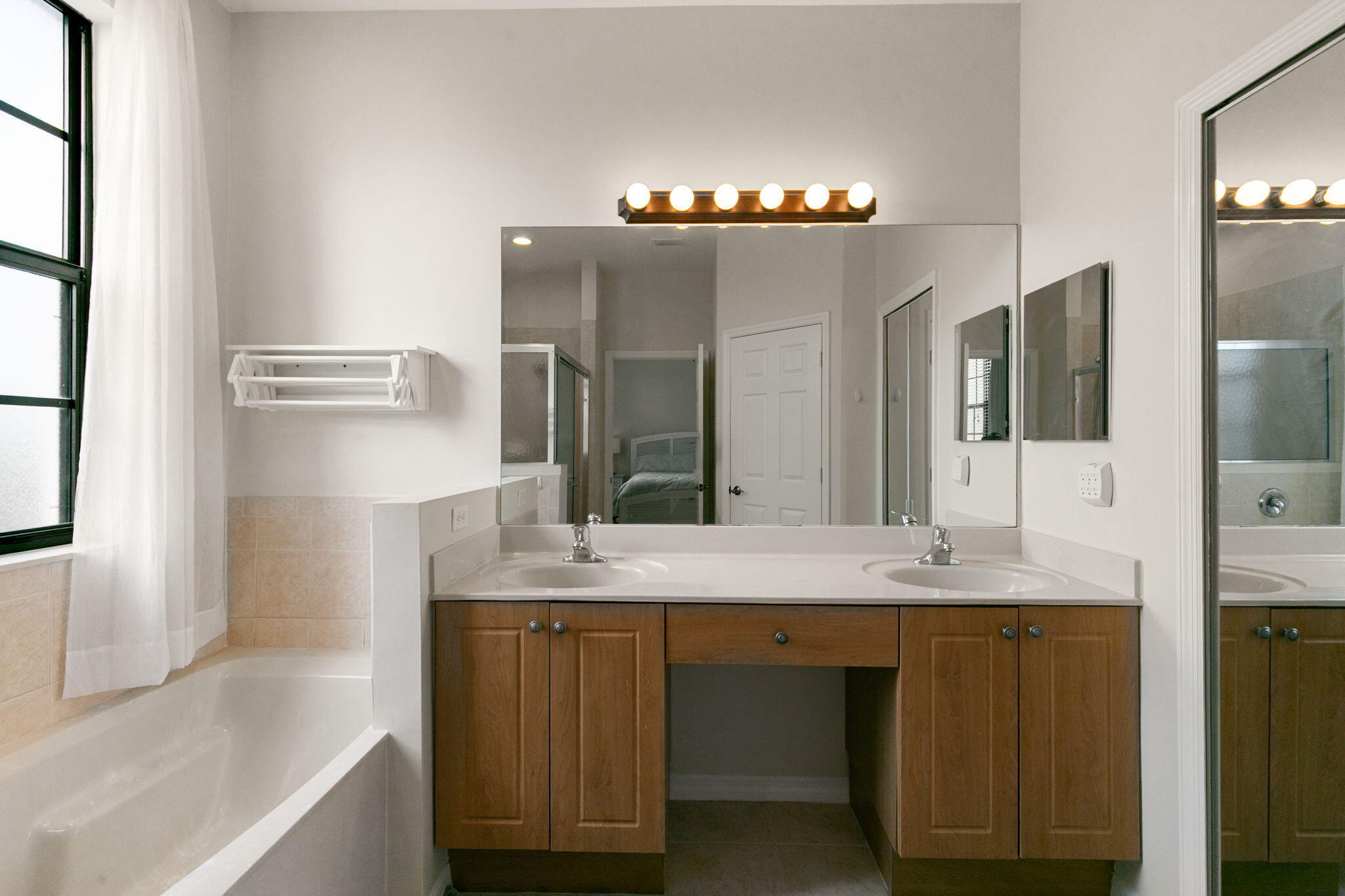 15068 Summit Pl Circle Naples, FL 34119 - Photo 15 of 29 a bathroom with a granite countertop sink a large mirror and a bathtub