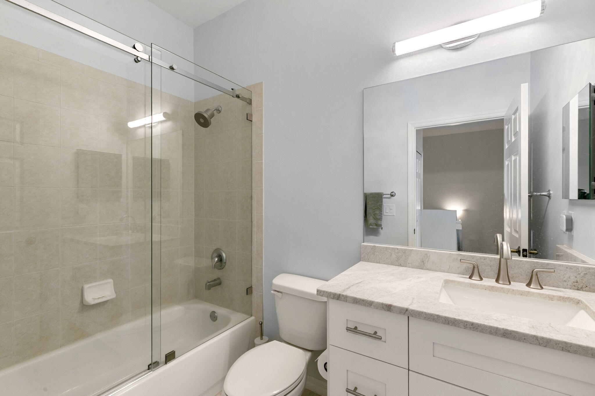 15068 Summit Pl Circle Naples, FL 34119 - Photo 19 of 29 a bathroom with a granite countertop sink a toilet and shower