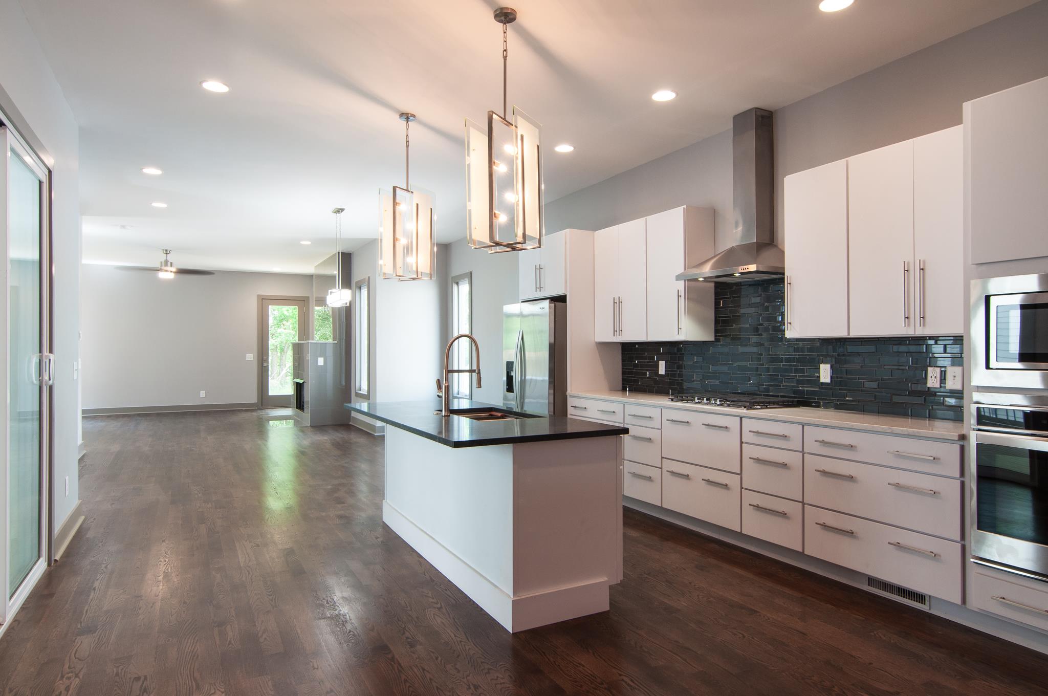 904 B Riverside Drive Nashville, TN 37206 - Photo 4 of 30 a kitchen with stainless steel appliances kitchen island a refrigerator a sink dishwasher a stove and white cabinets with wooden floor