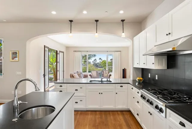a kitchen with kitchen island granite countertop a sink stainless steel appliances and cabinets
