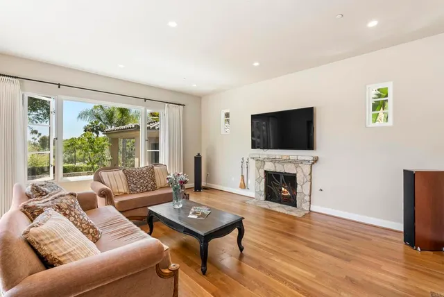 a living room with furniture a fireplace and a flat screen tv