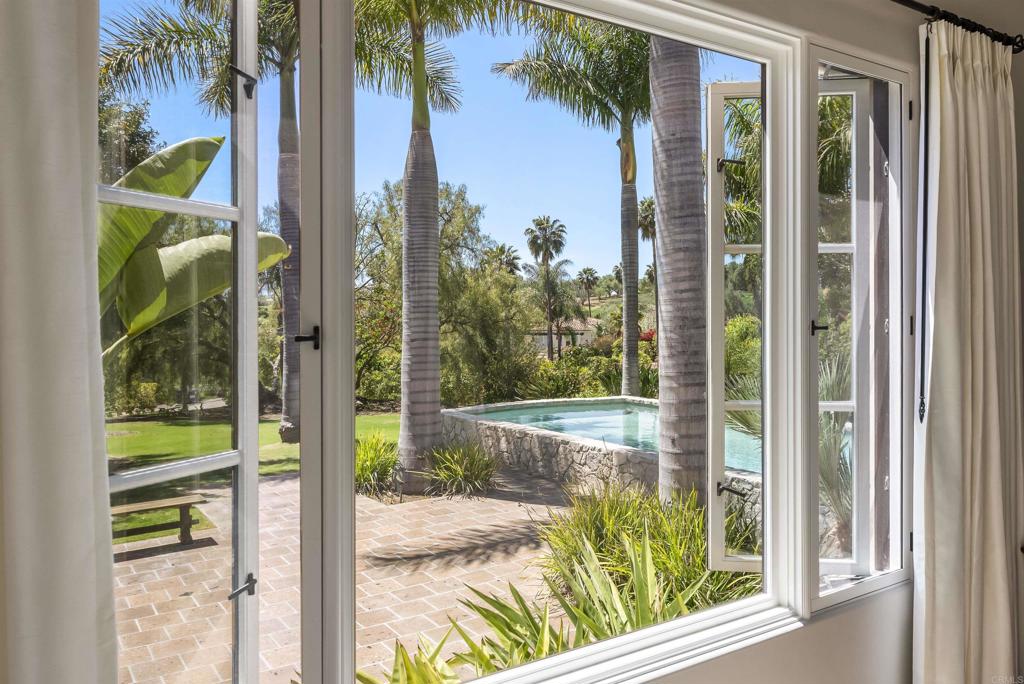 16733 Calle Hermosa San Diego, CA 92127 - Photo 25 of 43 a view of a porch with a floor to ceiling window and a yard