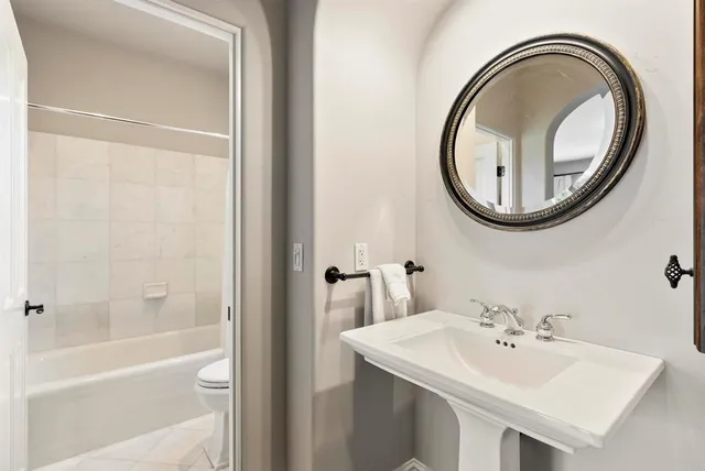 a bathroom with a sink a toilet and a mirror