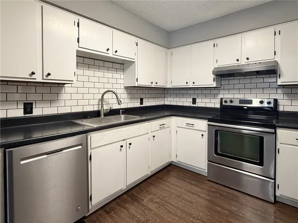a kitchen with a refrigerator sink and cabinets