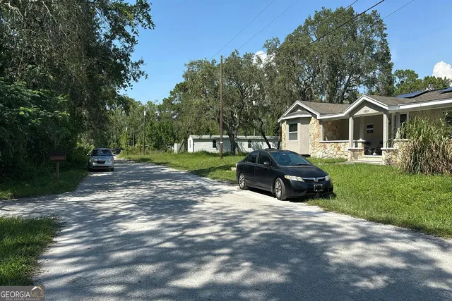 a front view of a house with a yard and trees