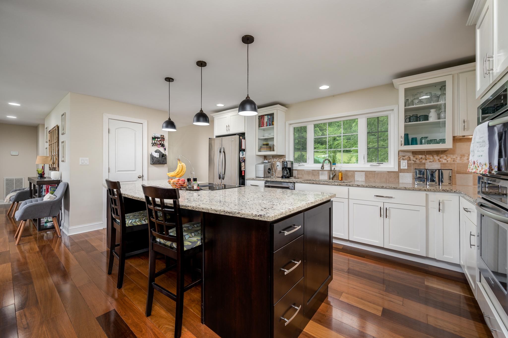 5252 Cainsville Road Lebanon, TN 37090 - Photo 13 of 45 a kitchen with stainless steel appliances granite countertop a stove a sink dishwasher a dining table and chairs with wooden floor