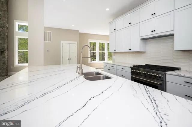 a kitchen with stainless steel appliances granite countertop a refrigerator and a stove