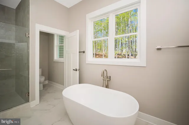 a front view of a house with a yard and potted plants