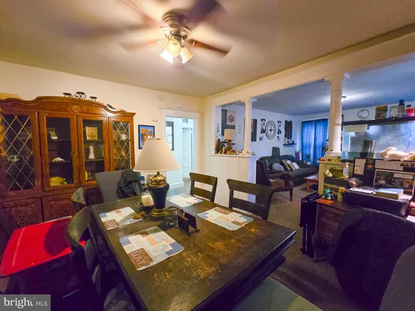 a living room with furniture a chandelier and a dining table