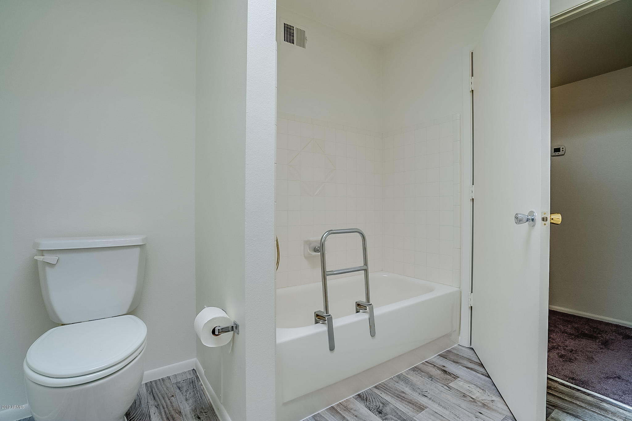3601 West Griswold Road Phoenix, AZ 85051 - Photo 27 of 40 a white toilet sitting next to a bathroom sink