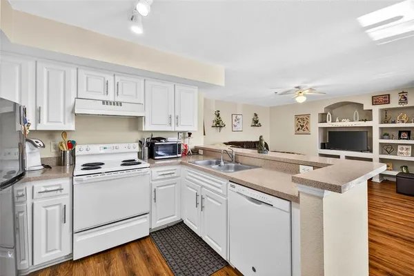 a kitchen with white cabinets sink and stainless steel appliances