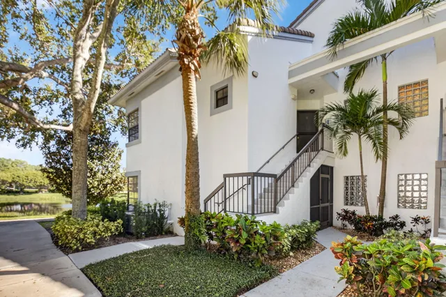 a front view of a house with a yard and potted plants