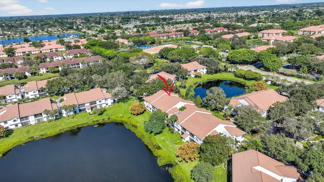an aerial view of a house with a garden and lake view