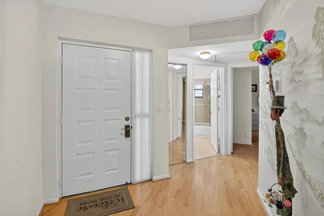 a view of a hallway with wooden floor and a potted plant