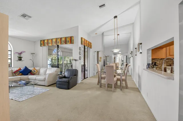 a dining room with furniture a chandelier and wooden floor