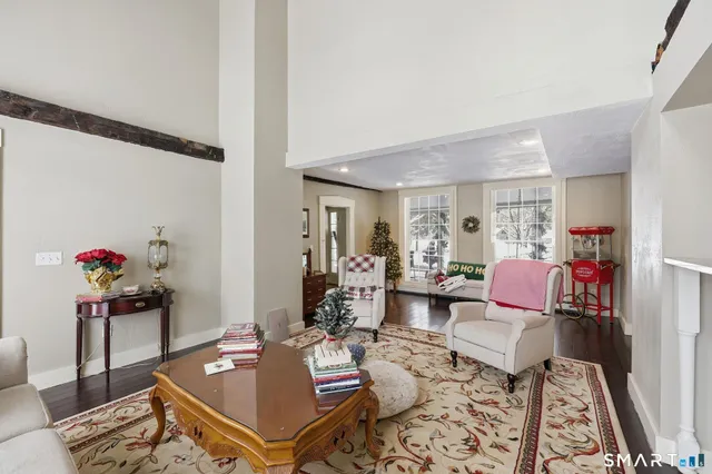 a view of a hallway with wooden floor and a living room