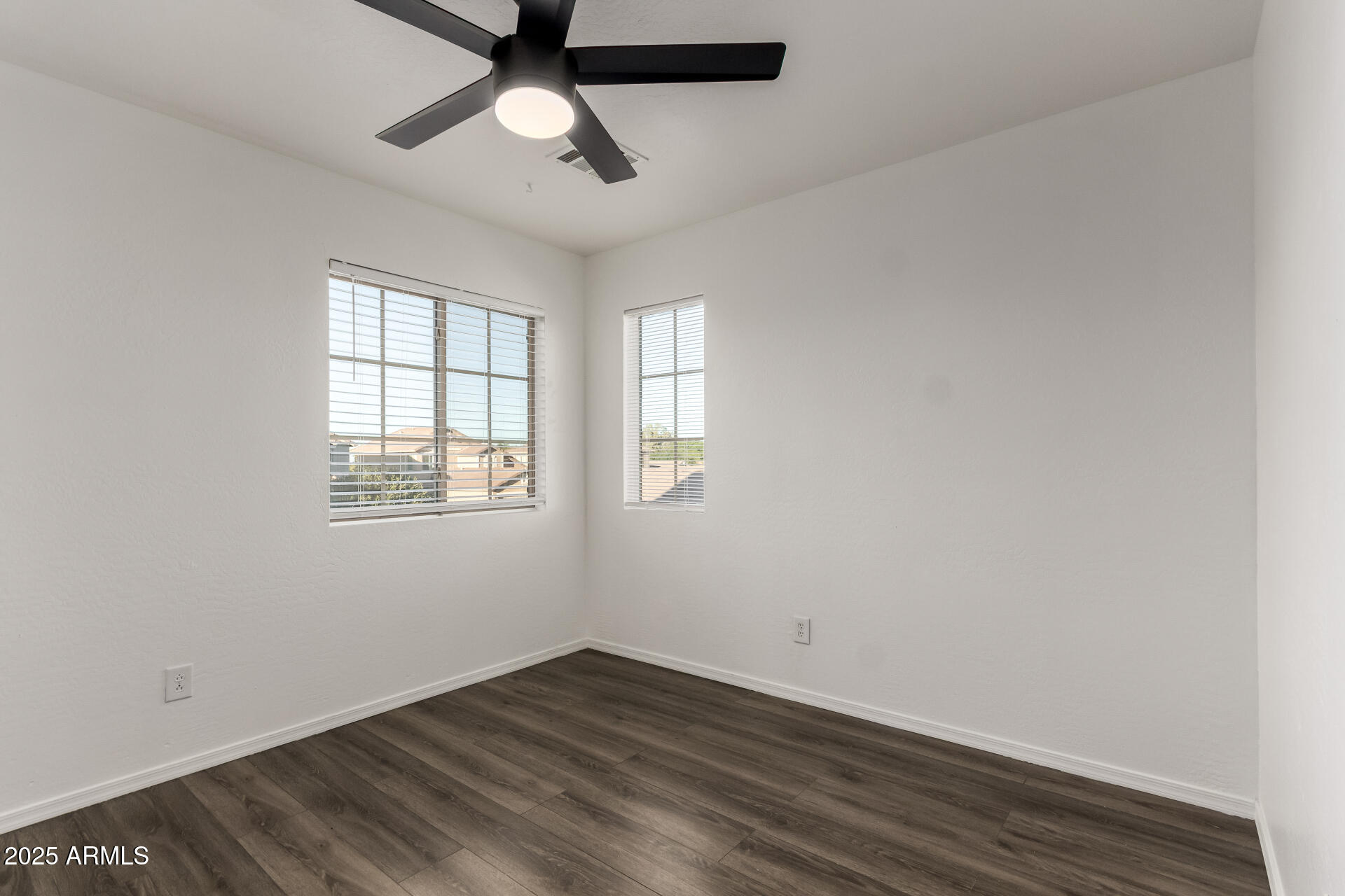 2507 West Desert Spring Way San Tan Valley, AZ 85144 - Photo 11 of 24 an empty room with wooden floor ceiling fan and windows