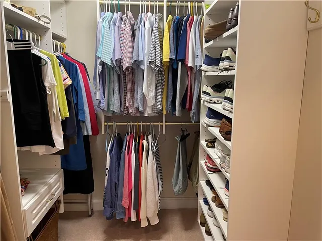a view of walk in closet with clothes