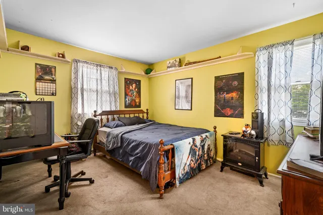 a bedroom with a bed chair and a window