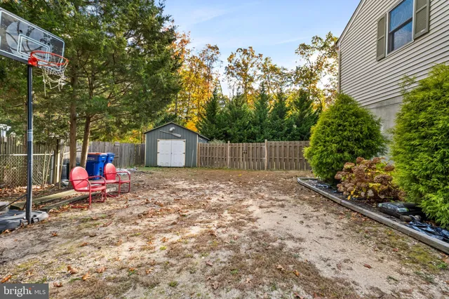 a view of a house with a small yard and a large tree