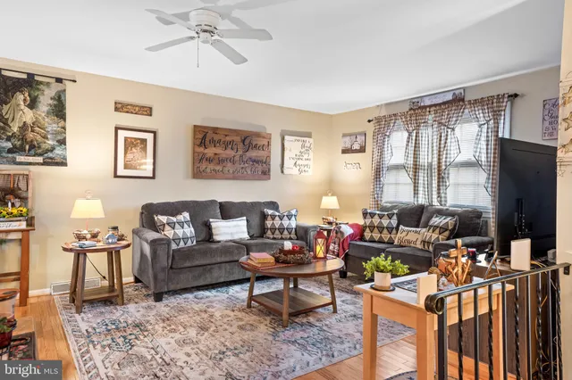 a living room with furniture a flat screen tv and a window