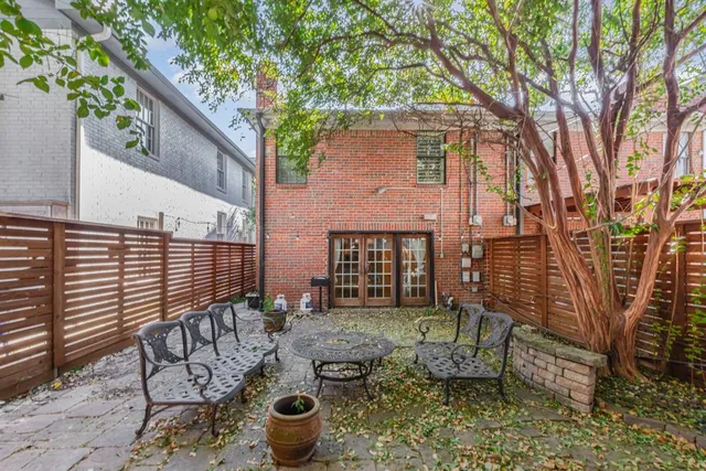 a view of a patio with table and chairs with wooden fence and plants