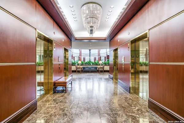 a view of a hallway with wooden floor and a potted plant