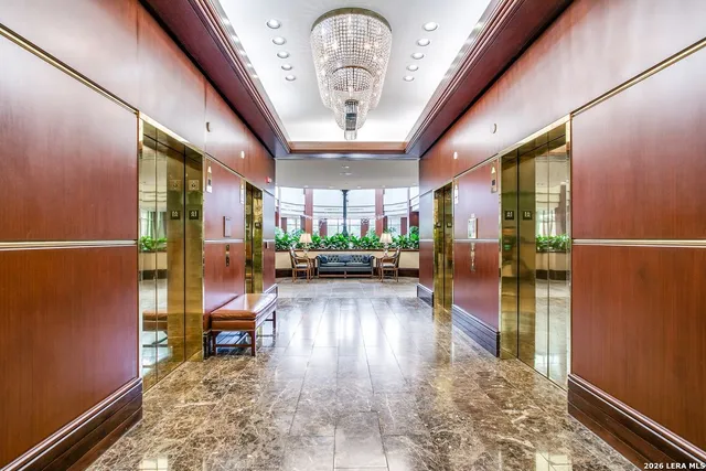 a view of a hallway with wooden floor and a potted plant