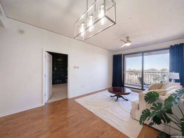 a view of a room with a large window wooden floor and cabinet