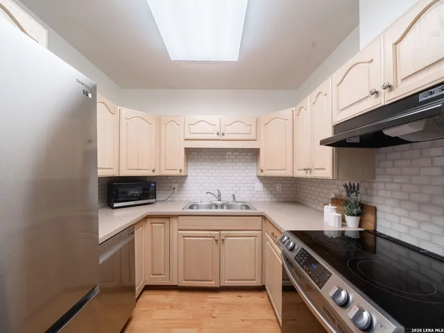 a kitchen with granite countertop a stove sink and cabinets