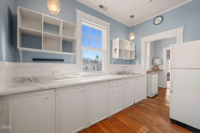a kitchen with a sink cabinets stainless steel appliances and a window